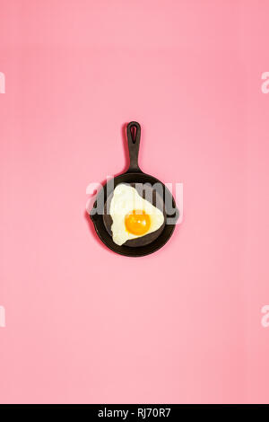 Magnifique œuf frit des aliments savoureux dans le moule, sur fond rose à la mode. Concept minimaliste. Vue d'en haut. Banque D'Images