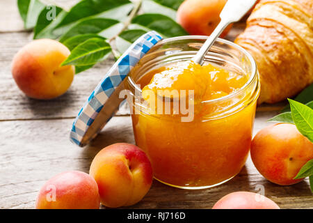 Confiture d'abricot orange fruit savoureux dans un bocal en verre avec des fruits sur la table en bois. Libre. Banque D'Images