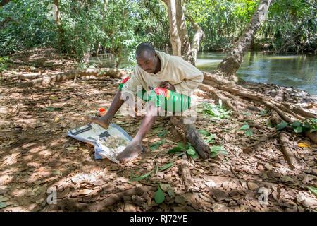 Village de Bodadiougou, district de Toumousseni, Banfora, région des Cascades, Burkina Faso, 4 décembre 2016; Yacouba Siri, cacheuse volontaire de mouche noire à la rivière Comoe à circulation rapide où la mouche noire qui porte le parasite de l'Onchosirciase comme se reproduire. Banque D'Images