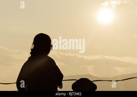 Silhouette de femme libre de détente paisible jouissant de la liberté au coucher du soleil sur la montagne en matinée dans un pur bonheur à Sun Set Point Mount Abu, de l'Inde. Prix f Banque D'Images