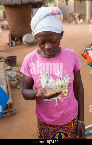 Karfiguela village, Banfora, Cascades Region, Burkina Faso, 6 décembre 2016; Maimouna Tou sur le point de prendre la bonne dose d'Ivermectin pour elle. Cela fait partie du programme visant à prévenir La Cécité des rivières dans la région. Banque D'Images