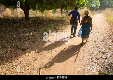 Village de Karfiguela, Banfora, région de Cascades, Burkina Faso, 6 décembre 2016; Lioutou Kone, (à gauche) et Mariam Sagnon, distributeurs de médicaments communautaires, en route entre les ménages. Banque D'Images