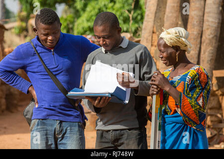 Village de Karfiguela, Banfora, région de Cascades, Burkina Faso, 6 décembre 2016; Lioutou Kone, (à gauche) et Mariam Sagnon, distributeurs de médicaments communautaires, discutant du travail de la matinée avec l'infirmière en chef Appolinaire Dabire (en haut gris). Banque D'Images