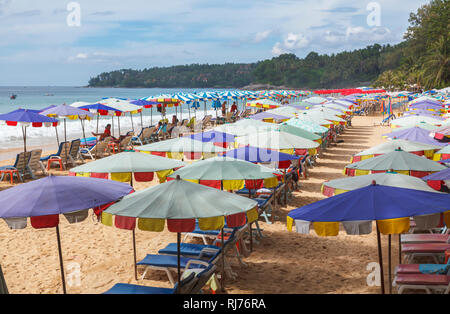 Des rangées de chaises longues et parasols colorés et des parasols sur la plage de rivage à Surin Beach, sur la côte ouest de Phuket, Thaïlande Banque D'Images