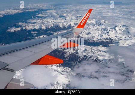 Aile de l'avion pendant le vol Easyjet sur la neige couverts Swiss Alps, Suisse. Banque D'Images