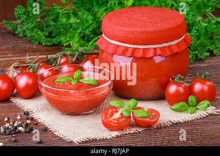 Pâte de tomates et les tomates mûres sur une vieille table en bois brun(selective focus). Banque D'Images