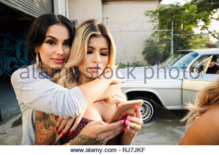 Confiant Portrait jeune femme Latinx hugging ami en stationnement