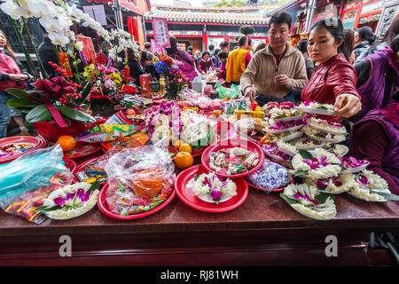 Taipei, Taiwan, le 5 février, 2019 : les visiteurs de Temple de Longshan à Taipei met des fleurs de lotus et autres offres sur un tableau offrant le mardi, jour du Nouvel An Lunaire, comme ils se félicitent de l'arrivée de l'année du cochon. Credit : Perry Svensson/Alamy Live News Banque D'Images