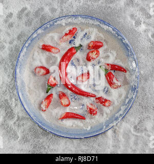 Rote Geschnittene Chilischoten auf blauem Teller mit Meersalz Banque D'Images