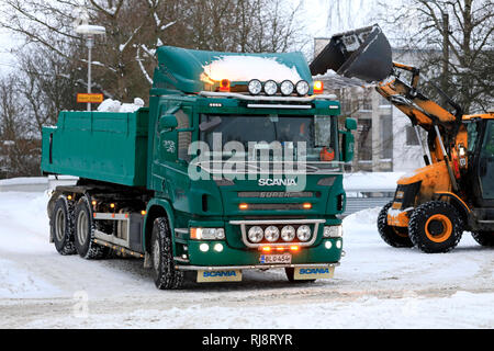 Salo, Finlande - le 2 février 2019 : la neige sur les charges du chargeur JCB green Scania P420 dump truck trailer pour être transportés à une zone de déversement de la neige. Banque D'Images