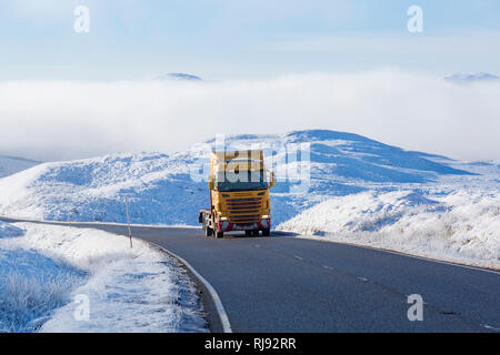 Phil Reid camion Scania voyageant le long de la route A82 sur journée d'hiver avec la neige autour et du brouillard givrant à Rannoch Moor, Highlands, Scotland en hiver Banque D'Images