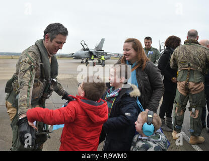 Commandant Commandant de l'Escadre Escadron IX James Heeps est accueilli par son fils Henry, William et George et sa femme Samantha après le dernier pilote RAF Tornado Gr4 retour à leur base à RAF Marham à Norfolk, après avoir réalisé les opérations dans le Moyen-Orient pour la dernière fois avant le départ de l'avion. Banque D'Images