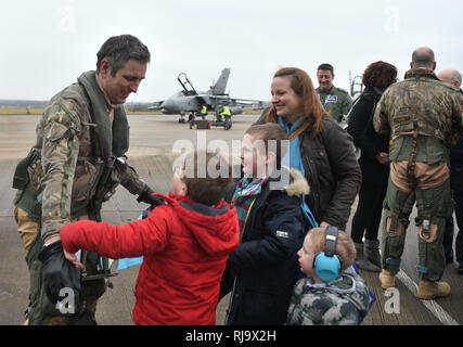 Commandant Commandant de l'Escadre Escadron IX James Heeps est accueilli par son fils Henry, William et George et sa femme Samantha après le dernier pilote RAF Tornado Gr4 retour à leur base à RAF Marham à Norfolk, après avoir réalisé les opérations dans le Moyen-Orient pour la dernière fois avant le départ de l'avion. Banque D'Images