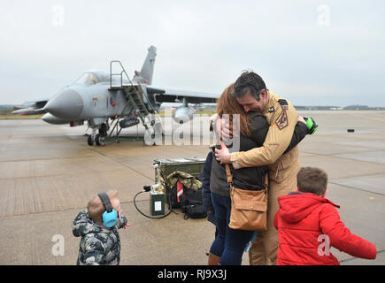 Commandant Commandant de l'Escadre Escadron IX James Heeps épouse sa femme Samantha après le dernier pilote RAF Tornado Gr4 retour à leur base à RAF Marham à Norfolk, après avoir réalisé les opérations dans le Moyen-Orient pour la dernière fois avant le départ de l'avion. Banque D'Images