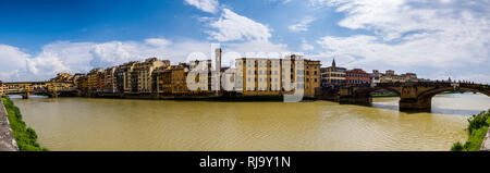 Vue panoramique sur les façades des maisons de l'autre côté de la rivière Arno, les ponts Ponte Vecchio et le Ponte Santa Trinita dans la distance Banque D'Images