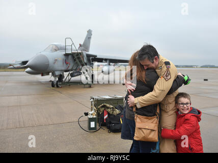 Commandant Commandant de l'Escadre Escadron IX James Heeps Samanthan avec sa femme et son fils Henry, 6, après le dernier pilote RAF Tornado Gr4 retour à leur base à RAF Marham à Norfolk, après avoir réalisé les opérations dans le Moyen-Orient pour la dernière fois avant le départ de l'avion. Banque D'Images