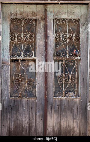 Vieille porte en bois avec des bars devant les fenêtres en Grèce Banque D'Images