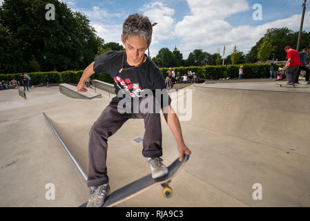 Un homme au niveau de patinage Skatepark à Brighton, East Sussex, Angleterre. Banque D'Images