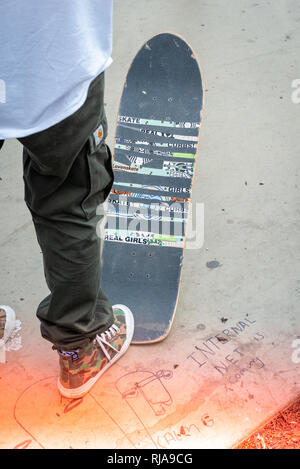 Patineur professionnel femme, Lucy Adams, pose son pied sur son skateboard tout en enseignant les filles comment patiner au niveau Skatepark à Brighton, à l'est Su Banque D'Images