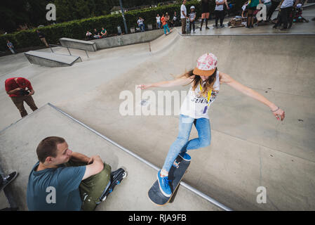 Une adolescente surveillé par un garçon alors qu'elle patine au niveau Skatepark à Brighton, East Sussex, Angleterre. Banque D'Images