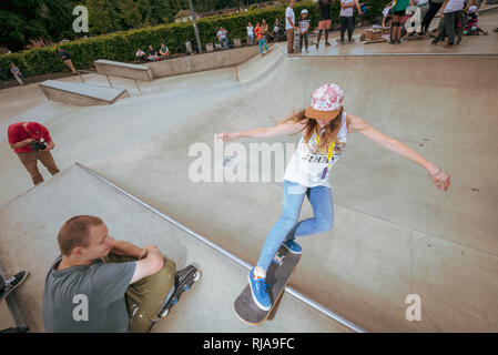 Une adolescente surveillé par un garçon alors qu'elle patine au niveau Skatepark à Brighton, East Sussex, Angleterre. Banque D'Images