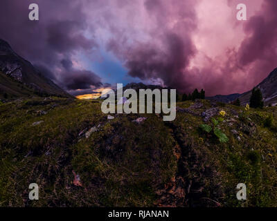 Panorama tente dans la montagne sur un fond de nuages pourpres au coucher du soleil Banque D'Images