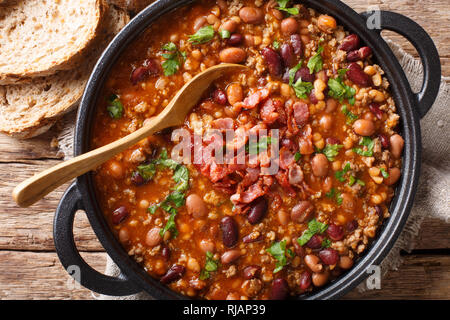 American Cowboy beans avec le boeuf haché, le lard dans une sauce épicée close-up sur la table supérieure horizontale. Vue de dessus Banque D'Images