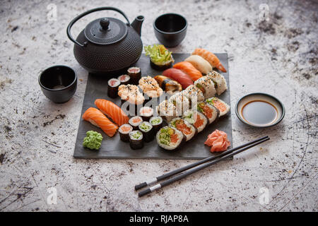 Assortiment de différents types de rouleaux de sushi sur pierre noire board Banque D'Images