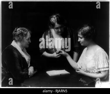 Helen Keller la lecture d'une femme comme les doigts d'une autre femme montres1914 Helen Keller (1880 - 1968), auteur américain, activiste politique, et conférencier. Elle a été la première personne atteinte de surdi-cécité pour gagner un baccalauréat en arts, elle a fait campagne pour le suffrage des femmes, les droits du travail, le socialisme, l'antimilitarisme, et d'autres causes semblables. Banque D'Images