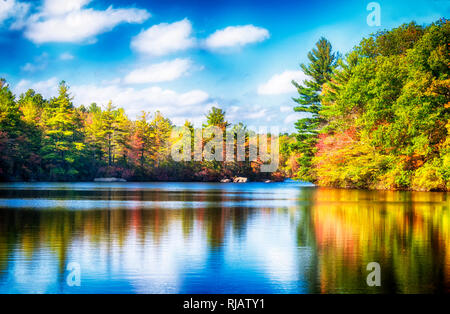 Le livre vert et en modifiant les couleurs, arbres se reflétant sur les eaux bleues à Burr State Park à Torrington, Connecticut sur une journée d'automne ensoleillée. Banque D'Images