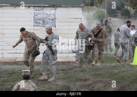 La Garde Nationale de Californie est le Sgt. James W. Peterson, Intel et le maintien en puissance de Co, 40e Division d'infanterie, à gauche, et Sgt. Fernando Carmona, 1113th Transportation Company, 340e Bataillon de soutien de la Brigade, 224e Brigade de soutien, l'assistance de leurs sponsors après la sortie d'une chambre à gaz au cours de la composition chimique, biologique, radiologique et nucléaire (CBRN) cas de la California's 2017 Concours meilleur guerrier 1-5 novembre 2016, au Camp de San Luis Obispo, San Luis Obispo, Californie. (Army National Guard Banque D'Images