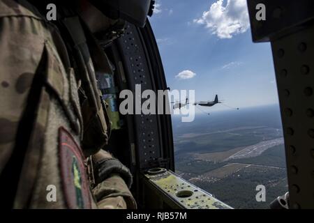 McSally Senior Airman Bernard, 41e Escadron de sauvetage missions spéciales aviator, regarde un HC-130J Combattre King II se prépare à faire le plein d'un HH-60G Pave Hawk au cours d'un exercice de sauvetage rapide, le 3 novembre 2016 près de la Base aérienne Tyndall, en Floride, au cours de l'exercice, ravitaillement en vol a eu lieu à démontrer les capacités pour maintenir l'exécution des opérations sans avoir à atterrir pour faire le plein. Banque D'Images