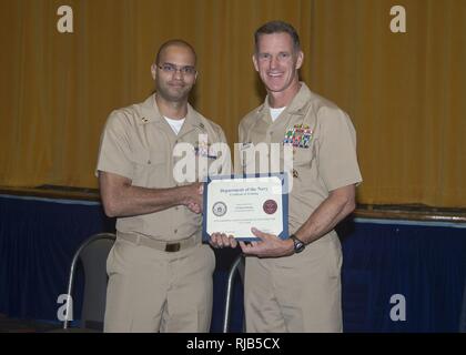 SAN DIEGO (nov. 4, 2016) Le lieutenant Kevin Beasley est félicité par Adm arrière. William Byrne, commandant du groupe aéronaval, 11, au cours d'une cérémonie de remise de diplômes et de Combat Naval Surface Mine Centre de développement (SMWDC) 17 nouveaux instructeurs tactiques de guerre de la base navale de San Diego. Beasley a été le 100e officier de guerre de surface d'obtenir leur diplôme d'SMWDC 90 jours intensifs au cours du WTI. La cérémonie est Byrne key note le président a dit, 'Vous êtes maintenant les enseignants, les entraîneurs et les mentors pour la flotte -- bien enseigner, coach bien et bien diriger." s'apparente à l'École d'armes de chasse de la Marine (TOP GUN) pour le meilleur de la Marine aviators, Banque D'Images