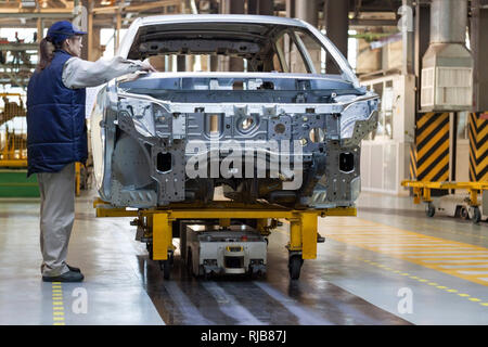 La Russie, Izhevsk - Décembre 15, 2018 : l'usine automobile Lada Izhevsk, partie du groupe AVTOVAZ. Le travailleur féminin vérifie le corps d'une nouvelle voiture. Assemblée Banque D'Images
