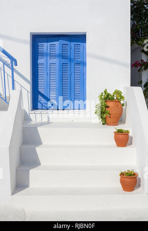 Maison blanche traditionnelle et des escaliers avec fenêtre bleu et cache-pot en Grèce - Grèce bleu et blanc Banque D'Images