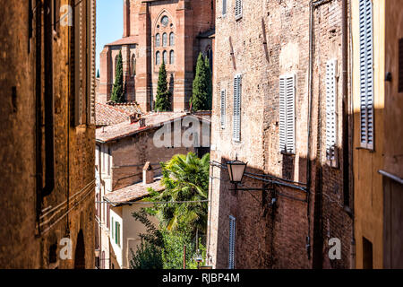 Sienne, Italie ruelle étroite dans la rue vieille ville médiévale historique village de Toscane avec personne au cours de journée d'été et les murs de l'architecture Banque D'Images