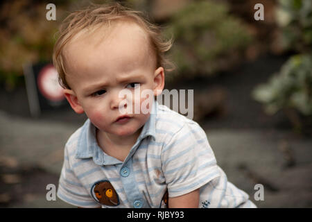 Enfant souriant en gros plan avec les cheveux blonds et l'expression heureuse. Banque D'Images