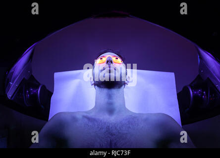 Jeune homme mince au solarium en instituts de beauté. Banque D'Images