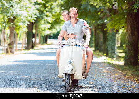 Couple riding on retro scooter Banque D'Images