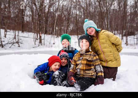 Cinq enfants assis dans la neige, Wisconsin, United States Banque D'Images