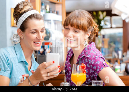Deux femmes looking at mobile phone Banque D'Images