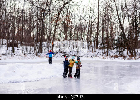 Quatre enfants de marcher sur un lac gelé, Wisconsin, United States Banque D'Images