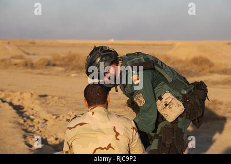 Un garde civil espagnol membre de la coalition montre un soldat irakien de Bagdad le commandement opérationnel, comment charger correctement son fusil M4 au cours d'un exercice de tir réel au Camp Besmaya, le 7 janvier 2018. Cette formation fait partie de la Force opérationnelle interarmées combinée globale - Fonctionnement résoudre inhérent à la mission de renforcer les capacités des partenaires qui se concentre sur la formation et l'amélioration de la capacité des forces des combats en partenariat avec ISIS. Les GFIM-OIR est la Coalition mondiale pour vaincre ISIS en Iraq et en Syrie. Banque D'Images