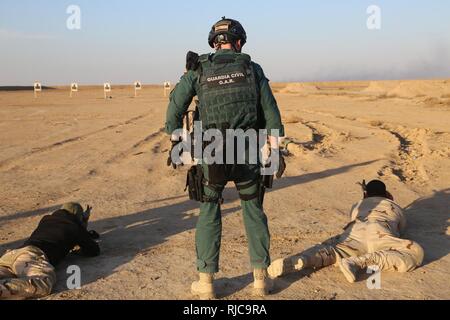 Un garde civil espagnol membre de la coalition est une sécurité tout soldat irakien de Bagdad du commandement opérationnel fire leurs fusils M4 au cours d'un exercice de tir réel au Camp Besmaya, le 7 janvier 2018. Cette formation fait partie de la Force opérationnelle interarmées combinée globale - Fonctionnement résoudre inhérent à la mission de renforcer les capacités des partenaires qui se concentre sur la formation et l'amélioration de la capacité des forces des combats en partenariat avec ISIS. Les GFIM-OIR est la Coalition mondiale pour vaincre ISIS en Iraq et en Syrie. Banque D'Images