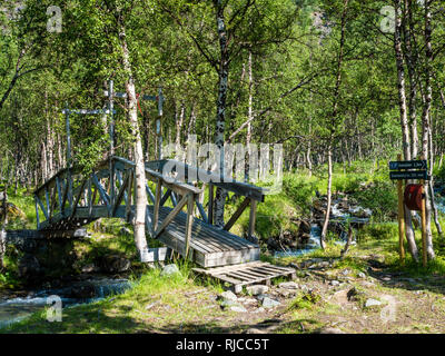 Pont de bois sur un chemin de randonnée traverse une petite rivière, randonnée le long de la vallée du glacier Steindalen Steindalsbre, Alpes de Lyngen, au sud du pays, Lyngseidet Troms Banque D'Images