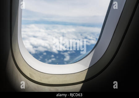 Ciel bleu et nuages avec regarder hors d'une fenêtre hublot avions lors d'un vol , image en utilisant pour sky et de l'intérieur du concept de l'avion Banque D'Images