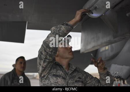 Le s.. Brett Rosales-Carr, 57e Escadron de maintenance des aéronefs, membre de l'équipage de charge ajuste morceaux d'un missile AIM-120 sur un avion de chasse F-15 Eagle au cours de l'équipe de chargement de l'année concurrence à Nellis Air Force Base, Nevada, le 8 janvier 2018. Le missile AIM-120 pèse plus de 300 livres et exige de l'équipement lourd pour transporter, charger et sécuritaire à bord de l'appareil. Banque D'Images