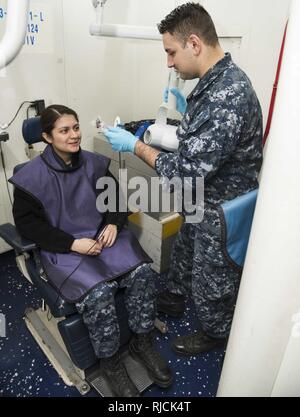 PORTSMOUTH (Virginie (janv. 11, 2018) Hospitalman Dustin Garner, droite, prépare l'Aviateur de l'Aviation Mécanicien structurels Jaquelin Ramirez pour une radiographie à bord du porte-avions USS Dwight D. Eisenhower (CVN 69). Eisenhower est l'objet d'une disponibilité progressive prévue (PIA) au chantier naval de Norfolk au cours de la phase d'entretien de la flotte (Plan d'intervention optimisés OFRP). Banque D'Images