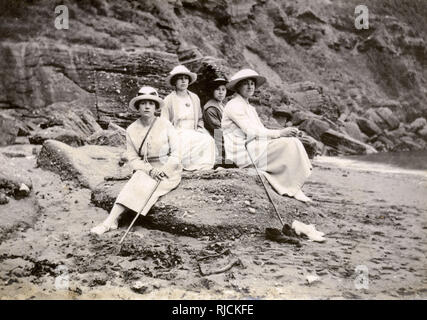 Groupe familial assis sur une plage au bord de la mer Banque D'Images