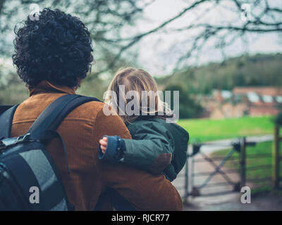 Un père est avec son petit garçon à l'extérieur dans un jardin Banque D'Images